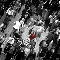 A lady in a red dress in a grey crowd of people A lady in a red dress in a grey crowd of people